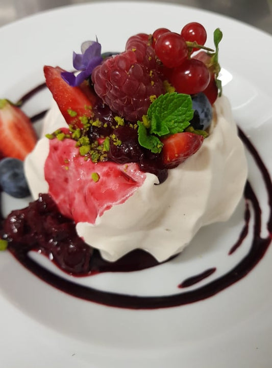 Samtaina bezē kūka ar kafijas krēmu, svaigajām ogām, bērza sīrupa mērci un šokolādes drumstalojumu